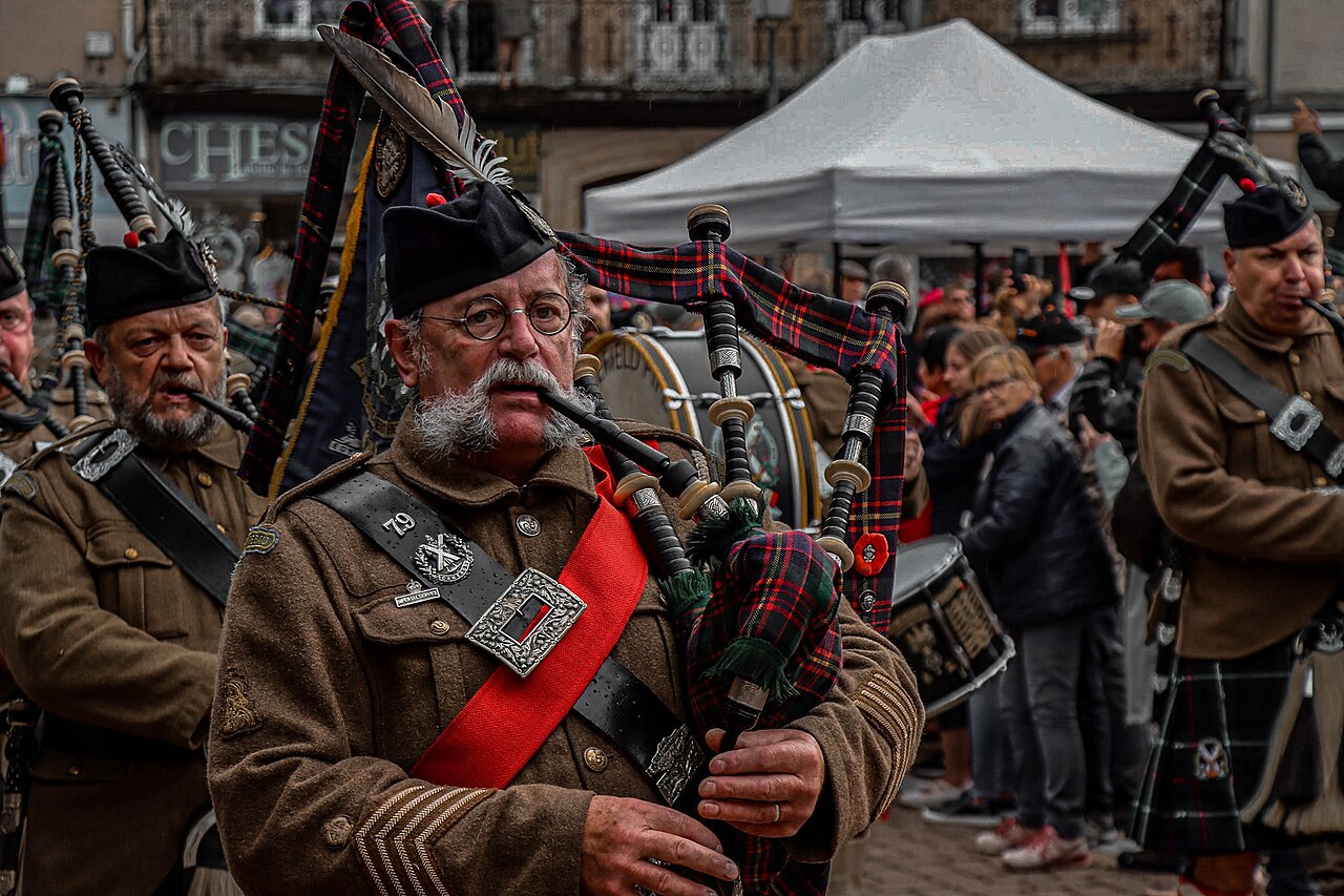 French bagpipe musicians march into Carentan town square during D-Day 78 celebrations, June 2022