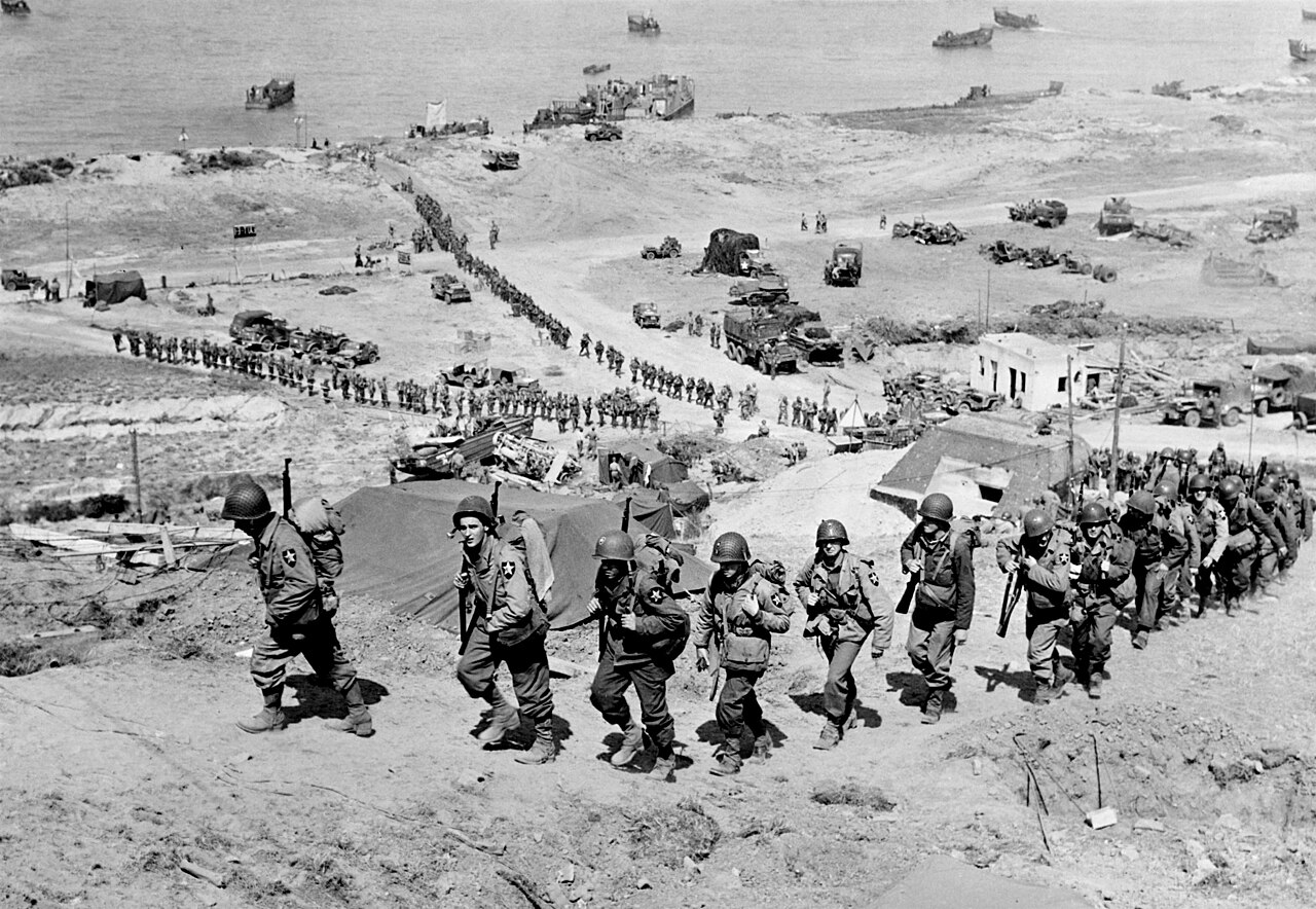 Troops of the US Army 2nd Infantry Division march up the bluff at the E-1 draw in the Easy Red sector of Omaha Beach, Normandy, France on D+1, June 7, 1944.